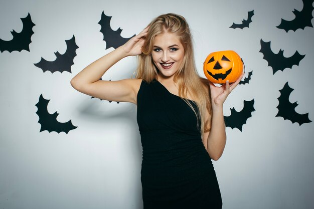 Blonde smiling woman posing with pumpkin