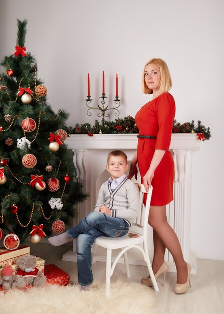 Blonde standing woman and her son in a chair