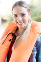 Free photo blonde teenager posing with a life jacket