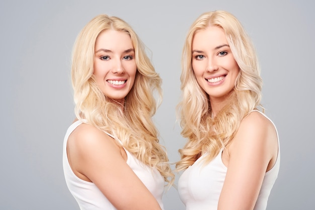 Blonde twins standing face to face
