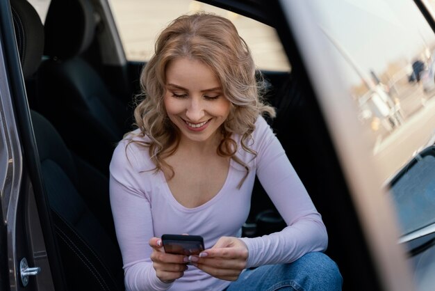 彼女の電話をチェックするブロンドの女性