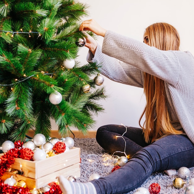 무료 사진 크리스마스 트리를 장식하는 금발 여자