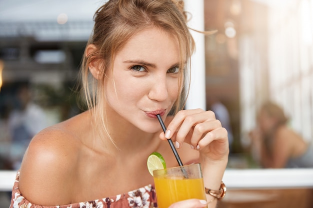 Blonde woman in floral dress in cafe