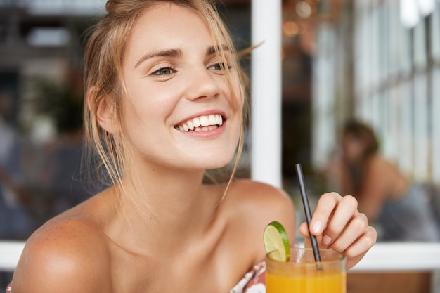 Blonde woman in floral dress in cafe