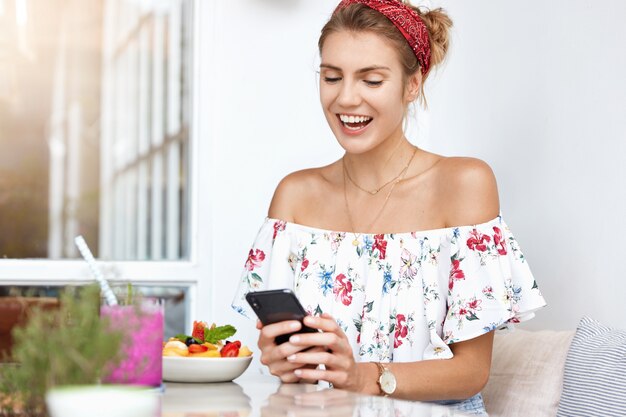 Free photo blonde woman in floral dress in cafe