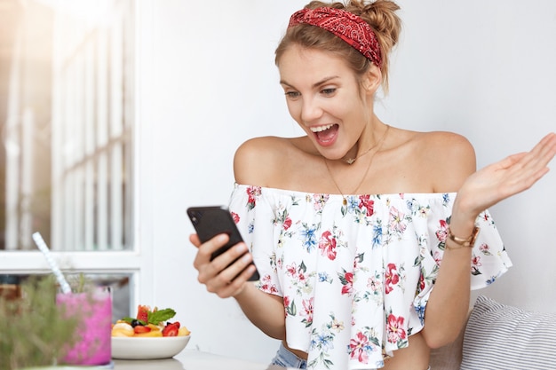 Blonde woman in floral dress in cafe