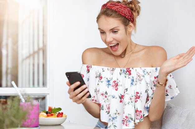 Blonde woman in floral dress in cafe