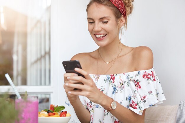 Blonde woman in floral dress in cafe