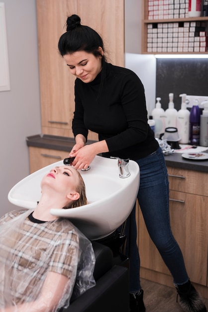 Free photo blonde woman getting her hair washed