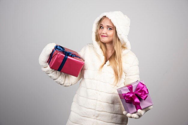 喜んでギフトボックスを見せている金髪の女性。