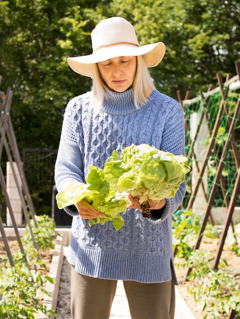 Free photo blonde woman holding fresh green cabbage