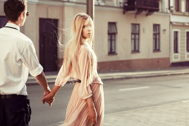 Blonde woman holding her boyfriend's hand