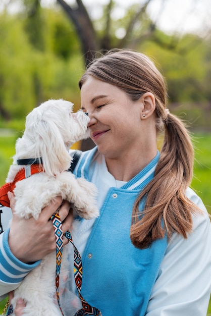 Free photo blonde woman holding maltese dog