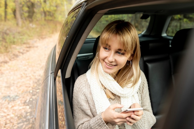 Foto gratuita donna bionda che tiene un telefono e distogliere lo sguardo