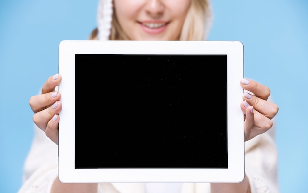 Free photo blonde woman holding a tablet with mock-up