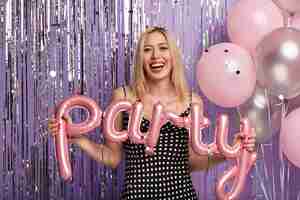 Foto gratuita donna bionda alla festa che tiene palloncini