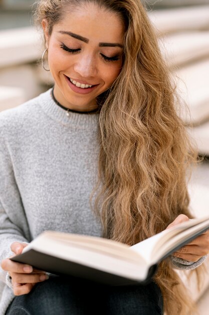 外の本を読んで金髪の女性