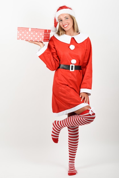 Блондинка в одежде Санта-Клауса, улыбаясь с подарочные коробки.