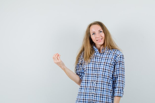 Blonde woman in shirt doing italian gesture and looking cheerful ,