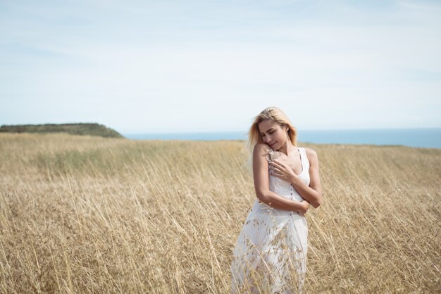 Blonde woman standing in field