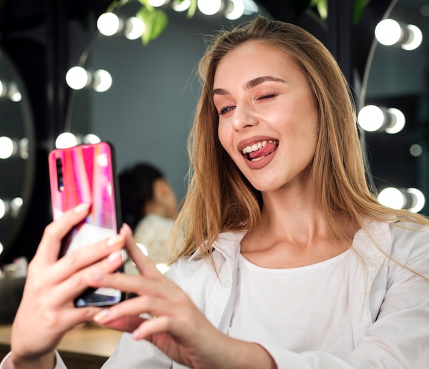 面白いselfieを取って金髪の女性