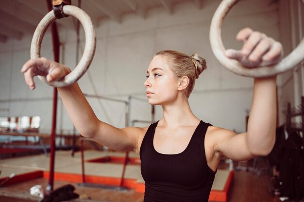 Blonde woman training on gymnastics rings