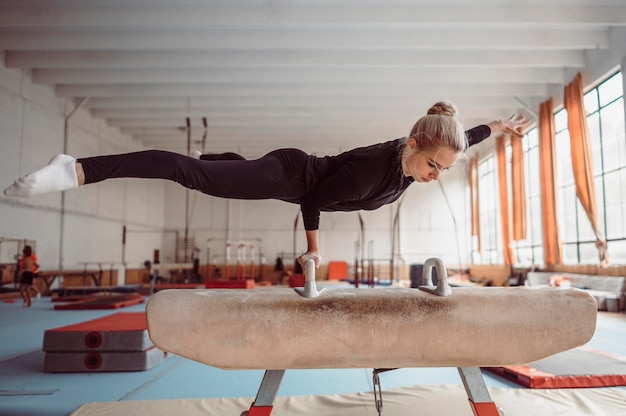 Blonde woman training on pommel horse