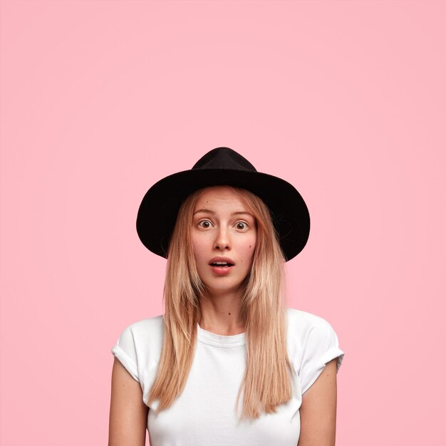 Blonde woman wearing big hat and casual T-shirt