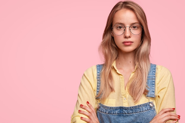 Free photo blonde woman wearing denim overalls