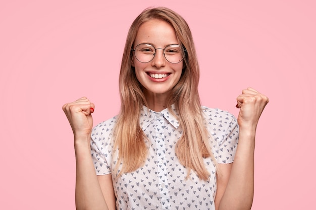 Donna bionda che indossa camicia punteggiata e occhiali da vista