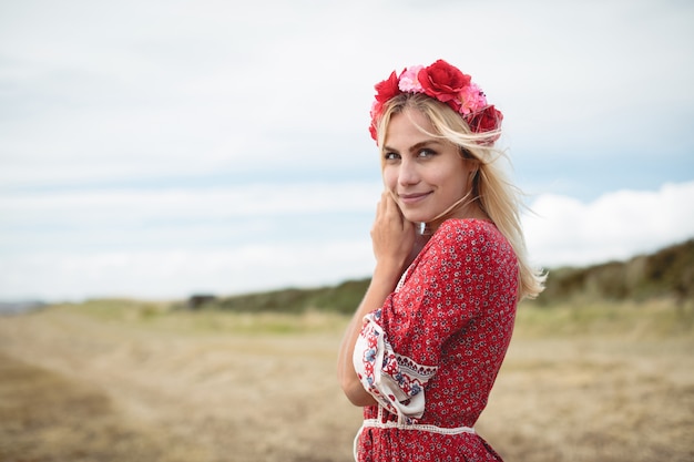 Blonde woman wearing a flower tiara standing in field