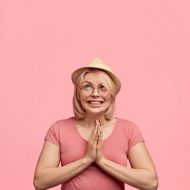 Blonde woman wearing pink t-shirt and hat