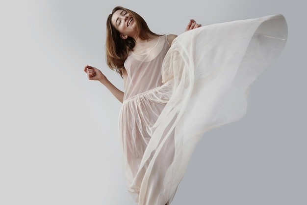 무료 사진 금발의 여자는 바람에 날리는 발레리나의 투명한 드레스를 입는다