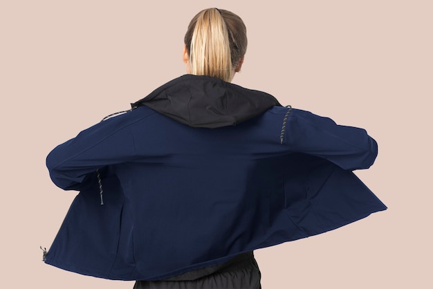 Blonde woman in windbreaker jacket for sportswear fashion photoshoot rear view