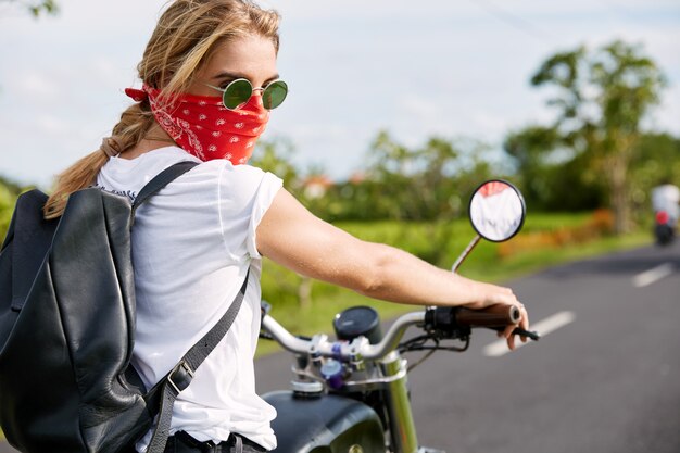 Blonde woman with bandana on motorbike