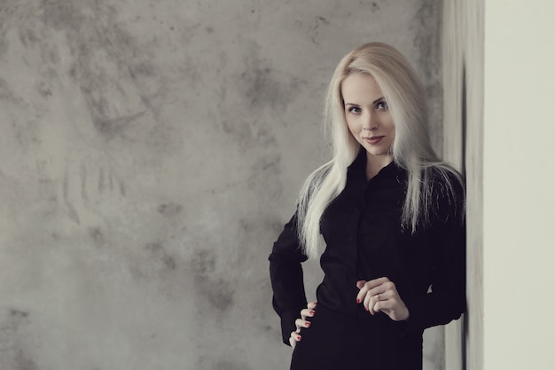 Blonde woman with black dress posing