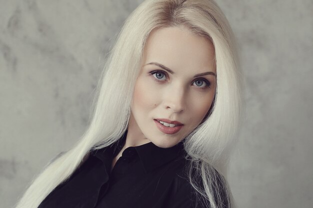 Blonde woman with black dress posing