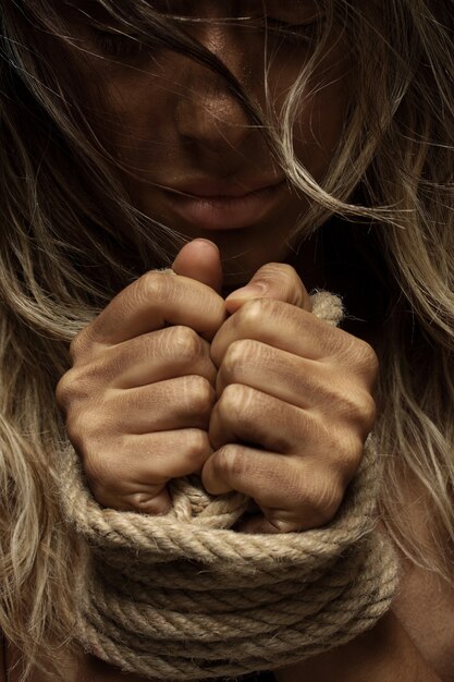 Blonde woman with hands tied