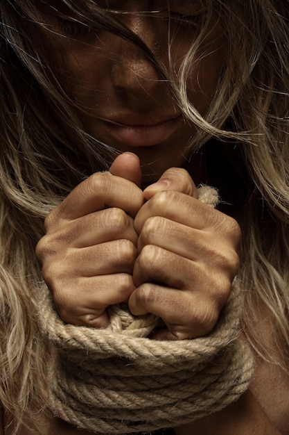 Blonde woman with hands tied