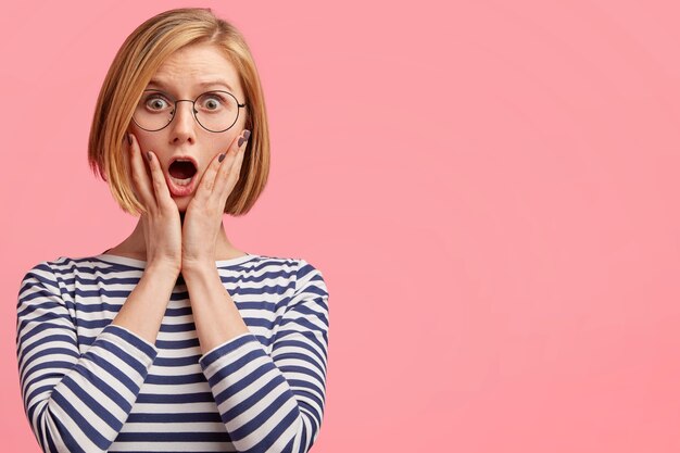 Blonde woman with round glasses and striped blouse