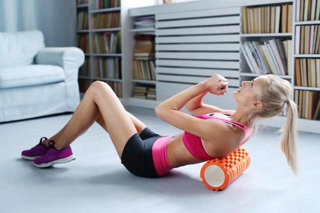 Free photo blonde woman workout exercises with foam roller