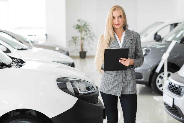 Blonde woman writing at the clipboard