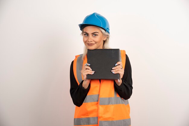 Blonde worker with notebook posing on white background. High quality photo