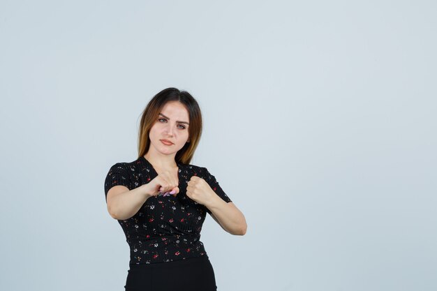 Blonde young lady in dress gesturing isolated