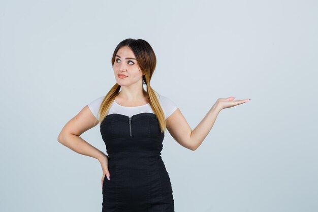 Blonde young lady in dress gesturing isolated