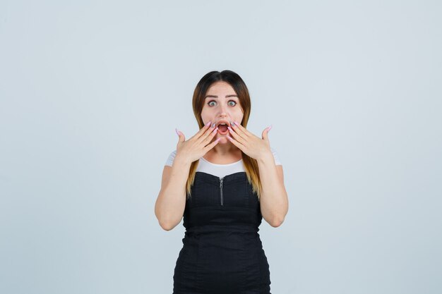 Blonde young lady in dress gesturing isolated