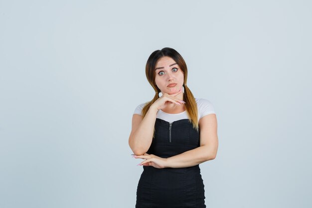 Blonde young lady in dress gesturing isolated