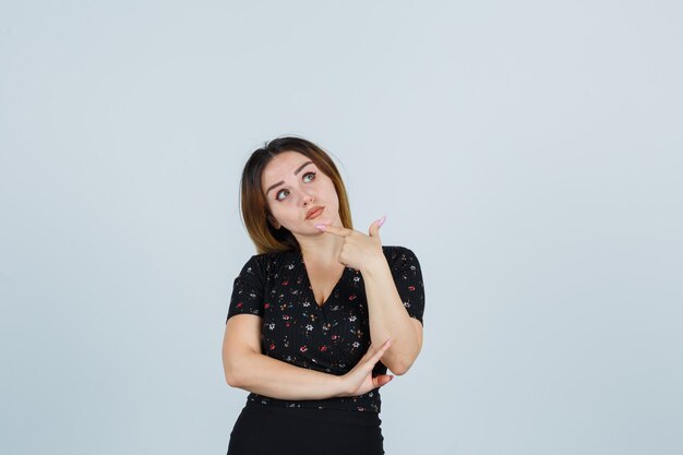 Blonde young lady in dress gesturing isolated