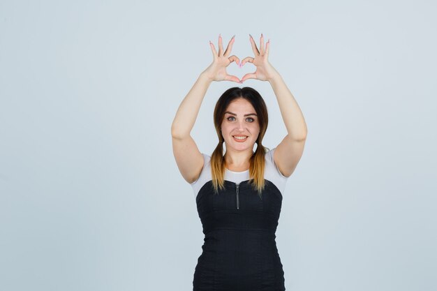 Blonde young lady in dress gesturing isolated