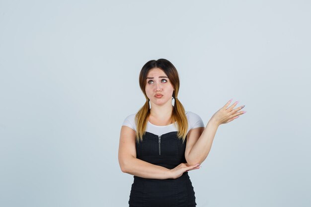 Blonde young lady in dress gesturing isolated